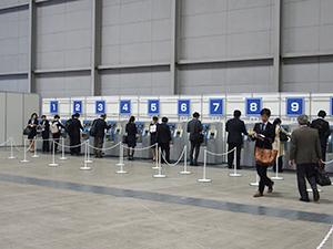 展示ホールAの総合受付　自動登録機で手続きする参加者