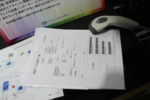 出力されたトークンシートと読み取り用バーコードリーダ