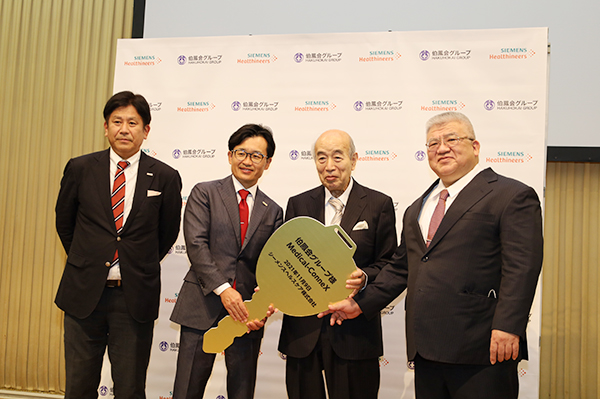 記者会見で登壇した4氏。左から，シーメンスヘルスケアの山本宣治 氏と森 氏，伯鳳会グループの山本保博 氏，古城 氏。