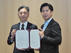 締結書を交わす西　恵一郎 氏（左：富士通CEO室室長）と篠原一生 氏（右：壱岐市長）